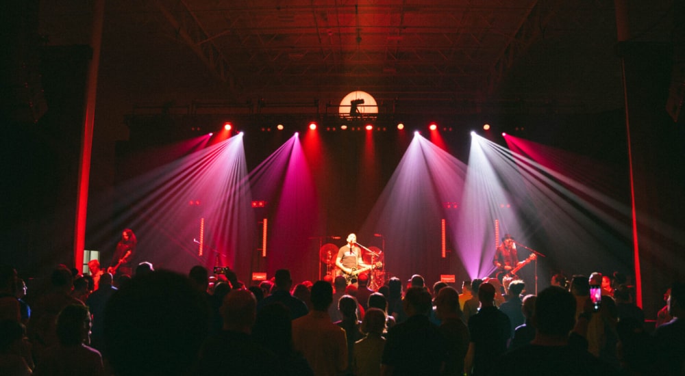 A band performing on stage with red and white lighting