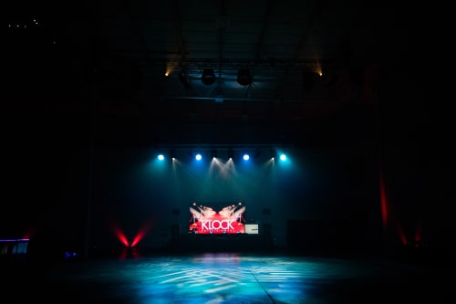 Empty dark arena with blue light shining on the stage