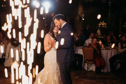 Couple sharing first dance with a zoomed in shot of the magic sparklers accenting the left frame